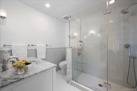 a bathroom with a granite countertop sink a toilet and shower