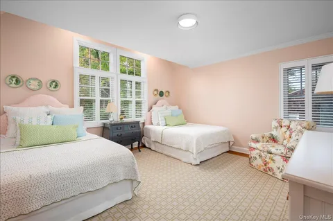 a bedroom with two beds and a large window