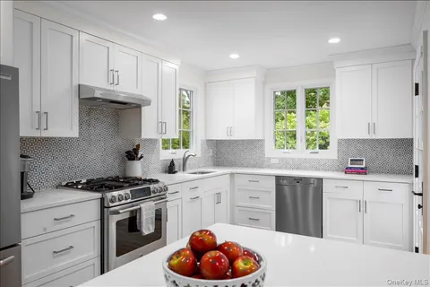 a kitchen with granite countertop a stove a sink and cabinets