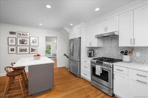 a kitchen with kitchen island a stove a sink and a refrigerator