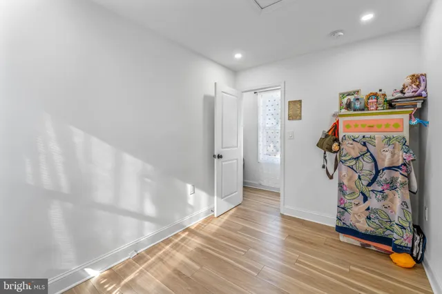 a view of a hallway with wooden floor and closet