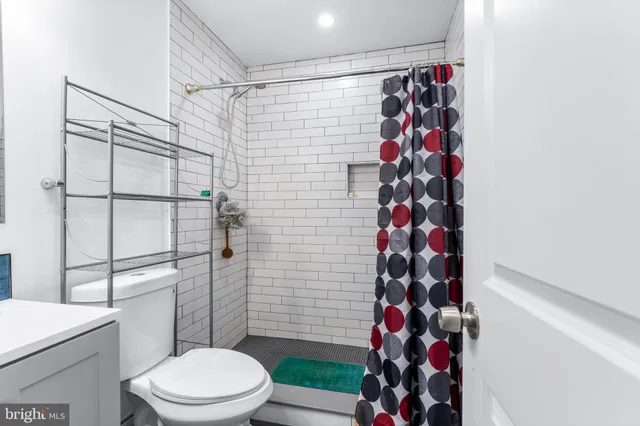 a white toilet sitting next to a shower curtain