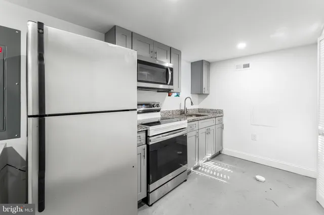 a kitchen with stainless steel appliances a refrigerator sink and microwave