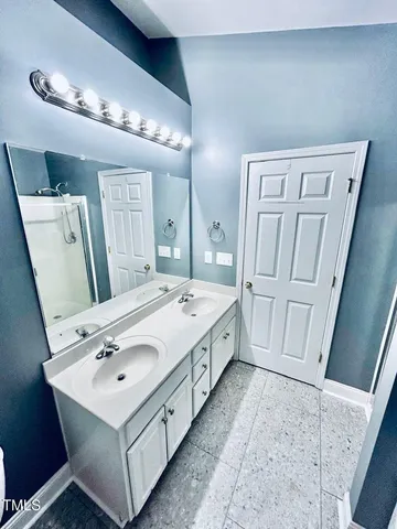 a spacious bathroom with a sink a mirror and vanity