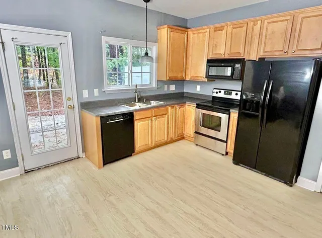 a kitchen with stainless steel appliances granite countertop a stove a sink dishwasher a refrigerator and a microwave