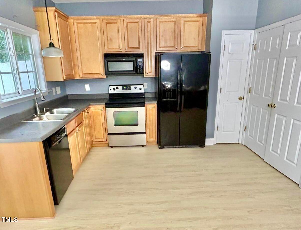 33 Sharpstone Lane Durham, NC 27703 - Photo 8 of 17 a kitchen with stainless steel appliances granite countertop a refrigerator a stove a sink and a microwave