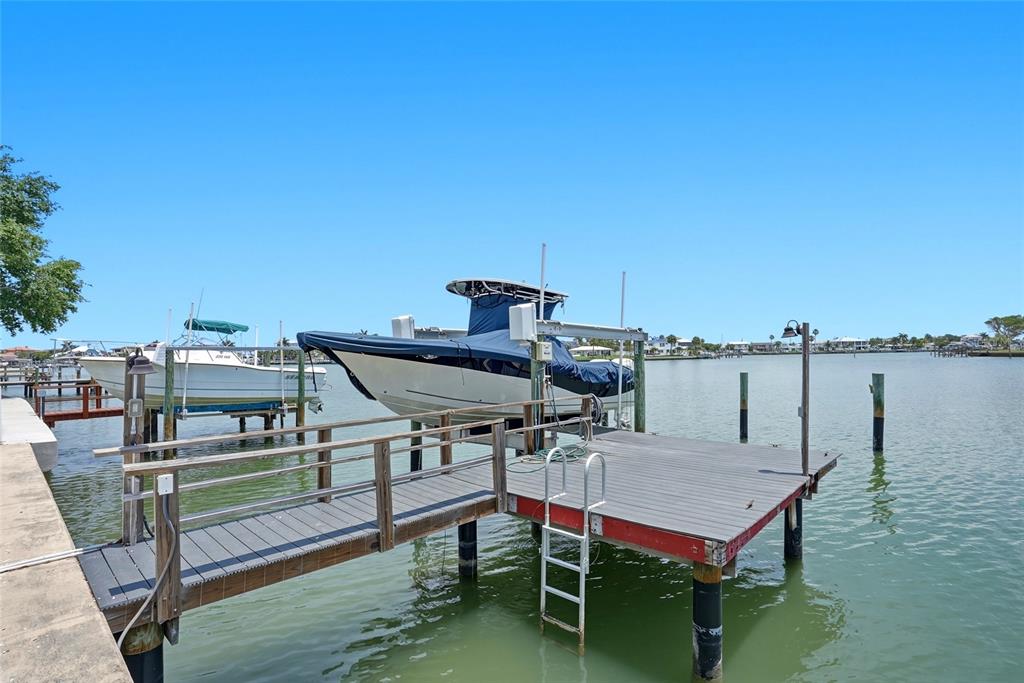 2311 Bay Boulevard Indian Rocks Beach, FL 33785 - Photo 4 of 80 a roof deck with table and chairs a barbeque with wooden floor and fence