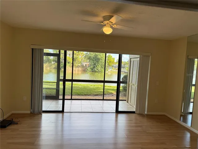 an empty room with fan and a floor to ceiling window