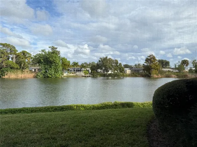 an aerial view of a houses with yard and lake view