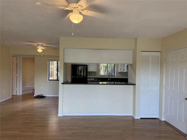 a view of a kitchen with a sink microwave and cabinets