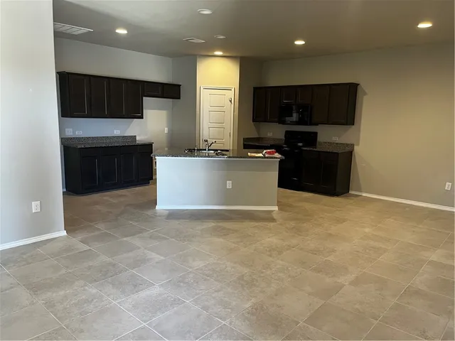 a kitchen with stainless steel appliances a stove a sink a microwave a refrigerator and cabinets