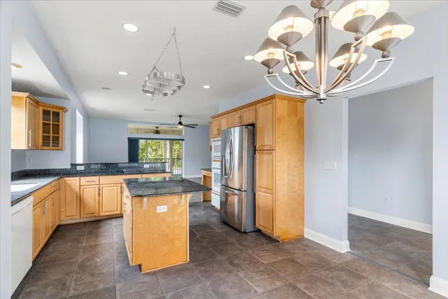 a kitchen with stainless steel appliances granite countertop a sink a stove and a refrigerator