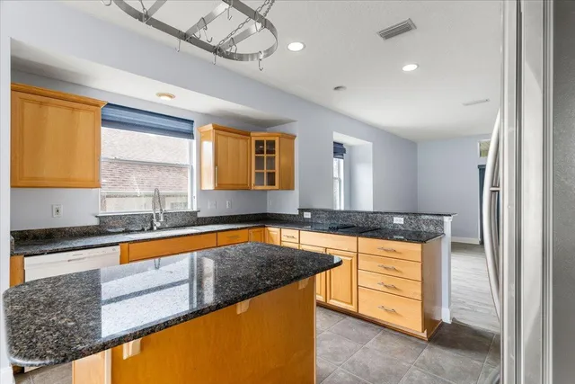 a kitchen with stainless steel appliances granite countertop a sink a stove and cabinets