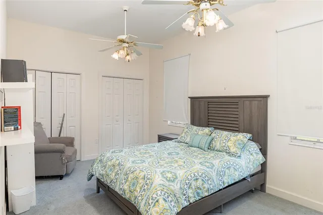 a bedroom with a bed chandelier and a window