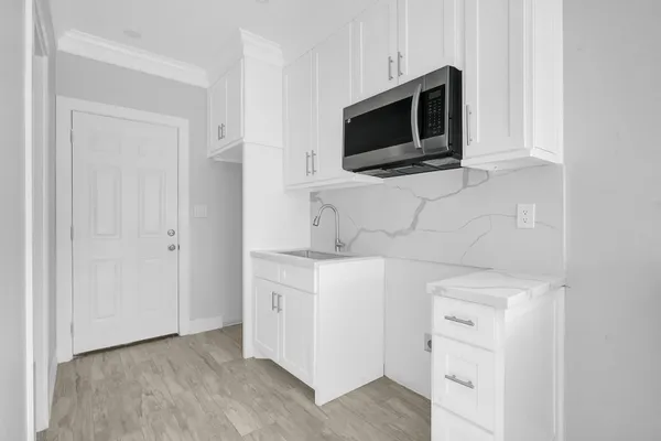 a kitchen with white cabinets stainless steel appliances and sink