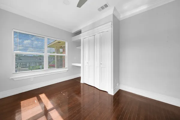 a view of kitchen and empty room with wooden floor and fan