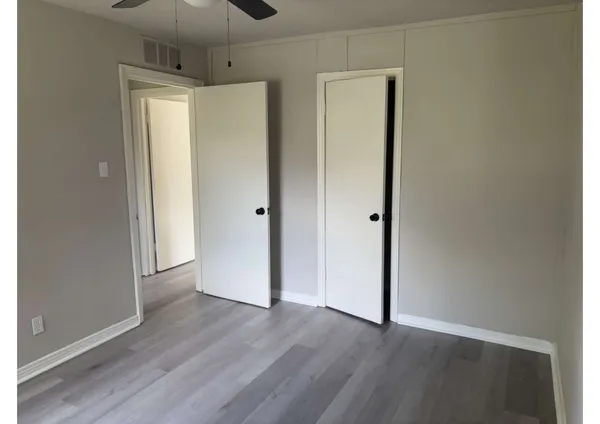 a view of an empty room with wooden floor