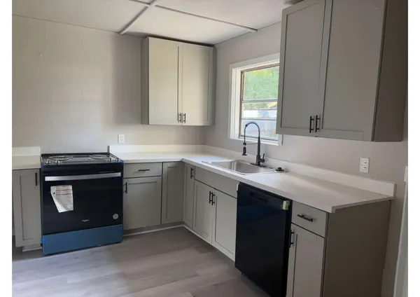 a kitchen with a sink stove and cabinets
