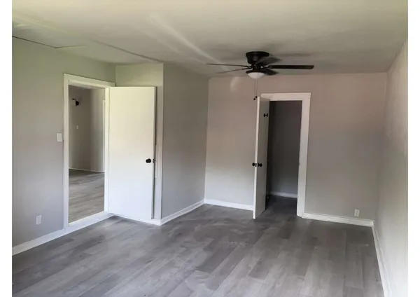 an empty room with closet and wooden floor