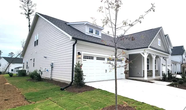 a view of a white house with a small yard and plants