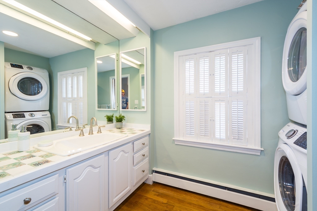 2 Beverly Road Natick, MA 01760 - Photo 28 of 40 a bathroom with a granite countertop sink and a large mirror next to a window
