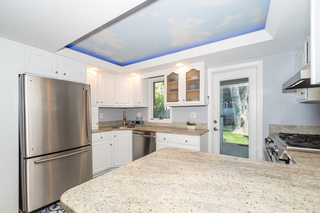 2 Beverly Road Natick, MA 01760 - Photo 10 of 40 a kitchen with a refrigerator a stove a sink dishwasher and white cabinets with wooden floor