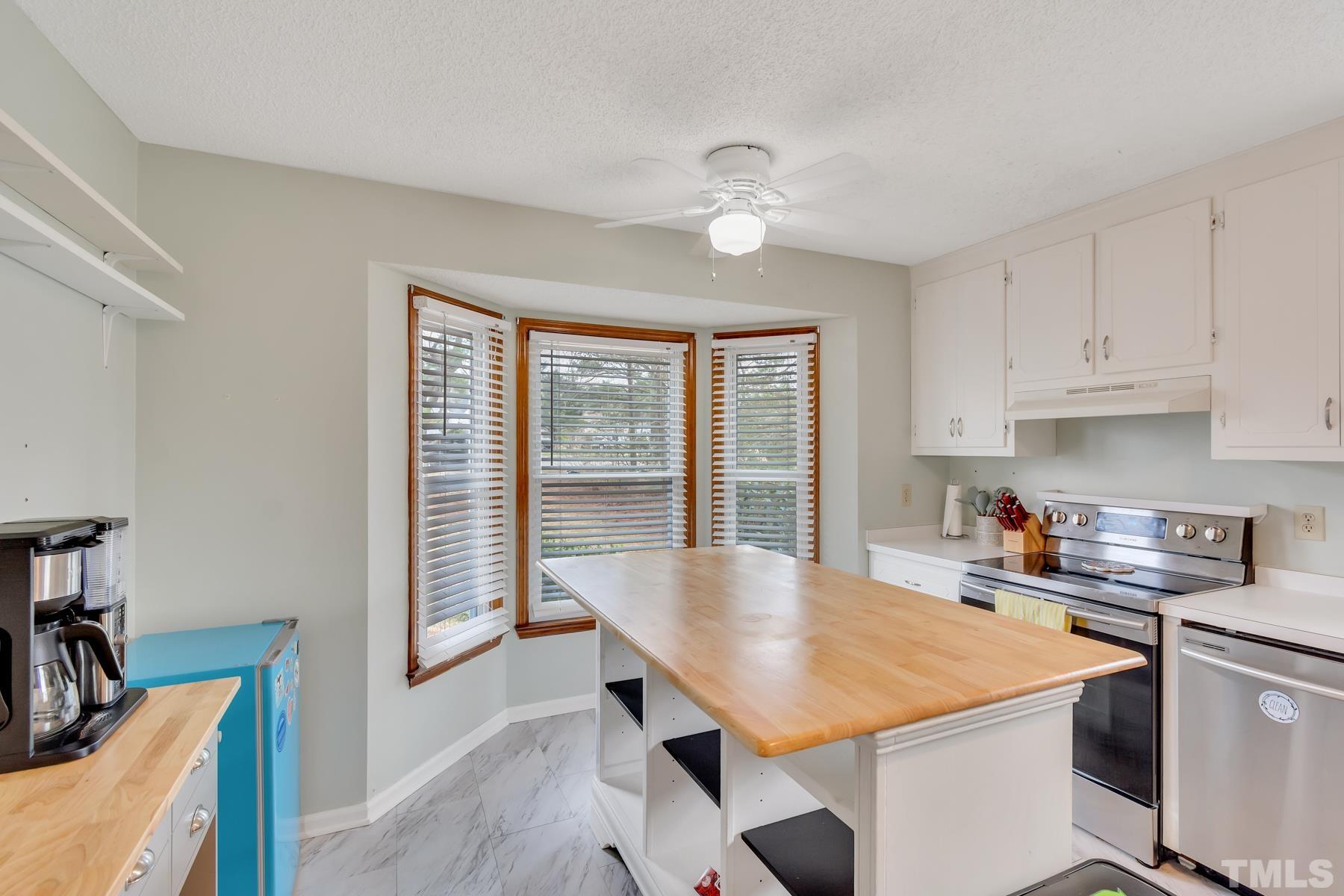 5244 Carrier Way Raleigh, NC 27603 - Photo 12 of 25 a kitchen with a table chairs and a refrigerator