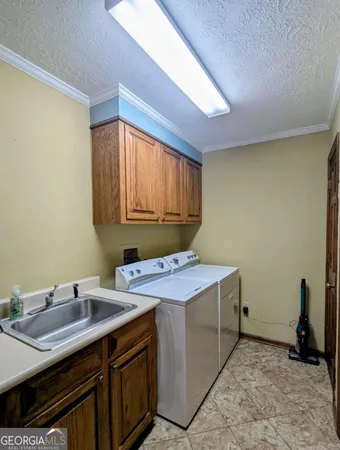 a room with a sink cabinets and utility