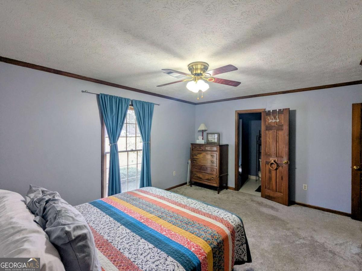 2005 Adams Street Vidalia, GA 30474 - Photo 25 of 50 a bedroom with a bed and a chandelier