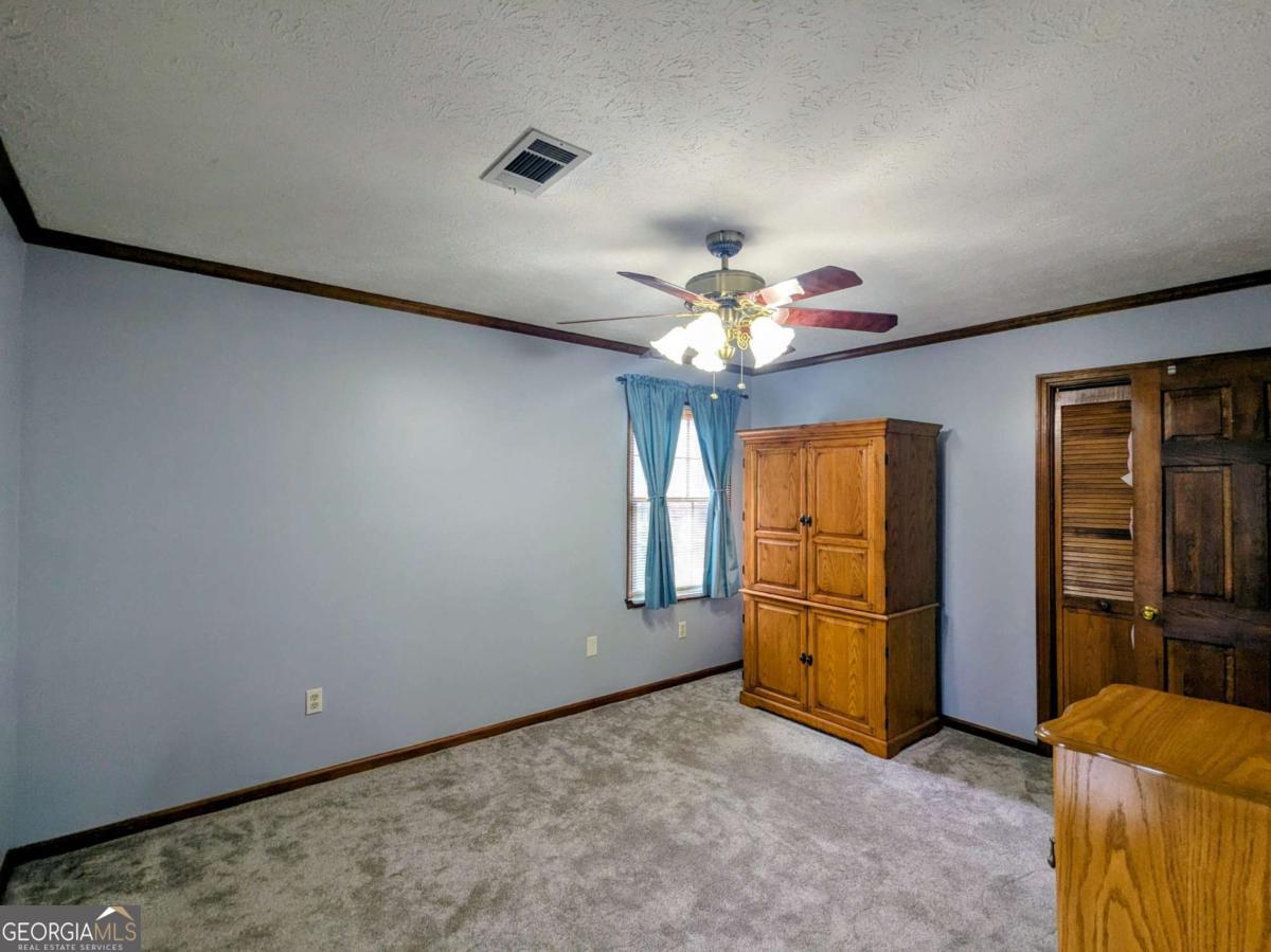 2005 Adams Street Vidalia, GA 30474 - Photo 28 of 50 an empty room with chandelier fan and windows
