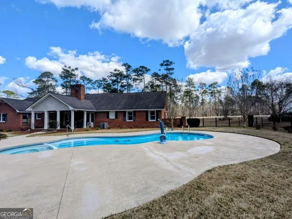 a view of a house with swimming pool yard and trees