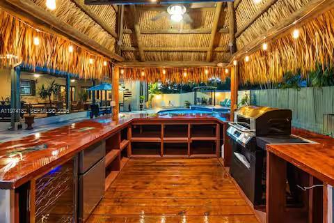 6140 Southwest 56th Court Davie, FL 33314 - Photo 53 of 69 Tiki-style outdoor kitchen under palm thatch roof!