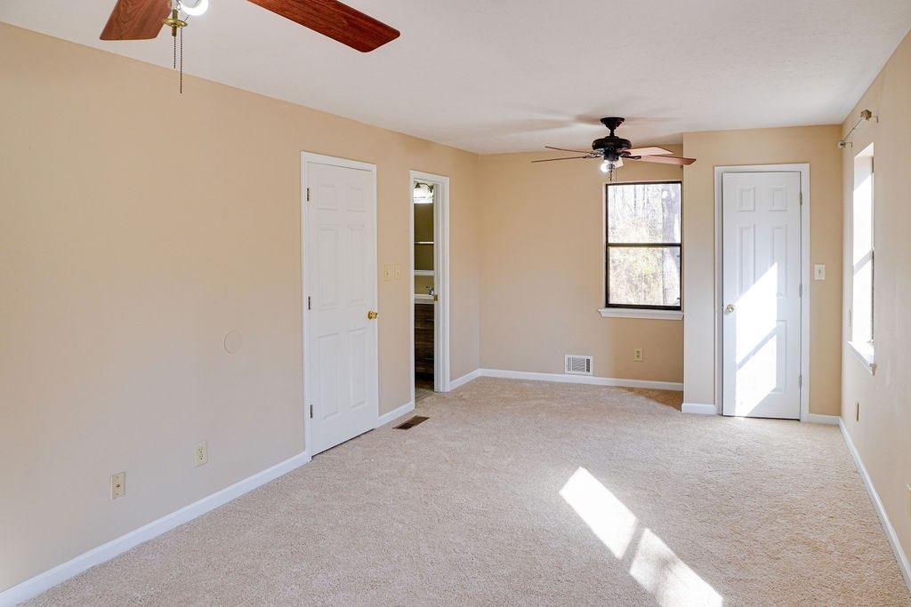220 Winding Stream Trail Hampton, GA 30228 - Photo 13 of 35 an empty room with windows and chandelier fan