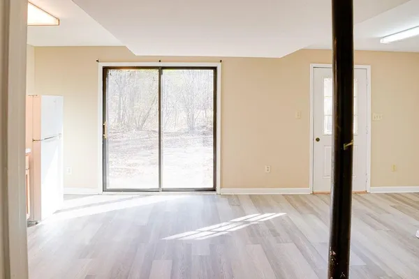 a view of a room with wooden floor and a window