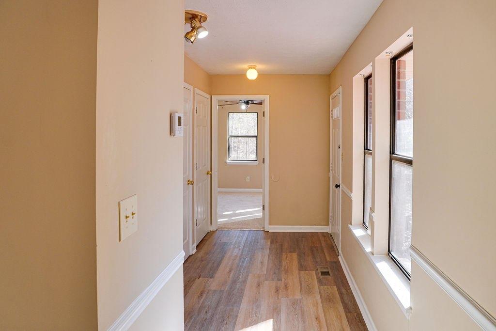 220 Winding Stream Trail Hampton, GA 30228 - Photo 4 of 35 a view of a hallway with wooden floor and a bathroom