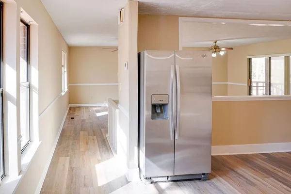 a view of a refrigerator in kitchen and wooden floor