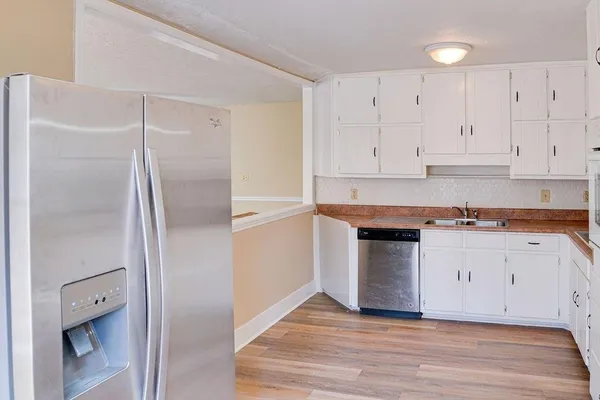 a kitchen with granite countertop white cabinets and stainless steel appliances