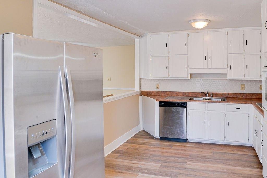 220 Winding Stream Trail Hampton, GA 30228 - Photo 8 of 35 a kitchen with granite countertop white cabinets and stainless steel appliances