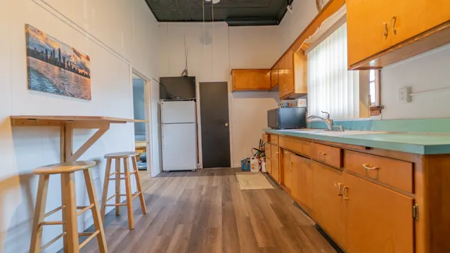 a kitchen with stainless steel appliances wooden floors and large window