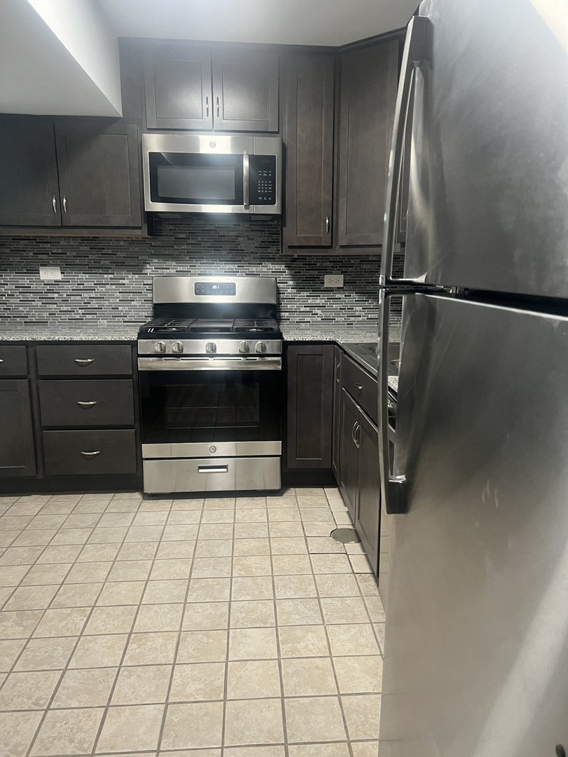 201 Custer Avenue, Unit G Evanston, IL 60202 - Photo 3 of 9 a kitchen with a stove a microwave and cabinets