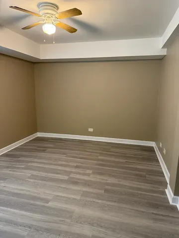 a view of a room with wooden floor and fan