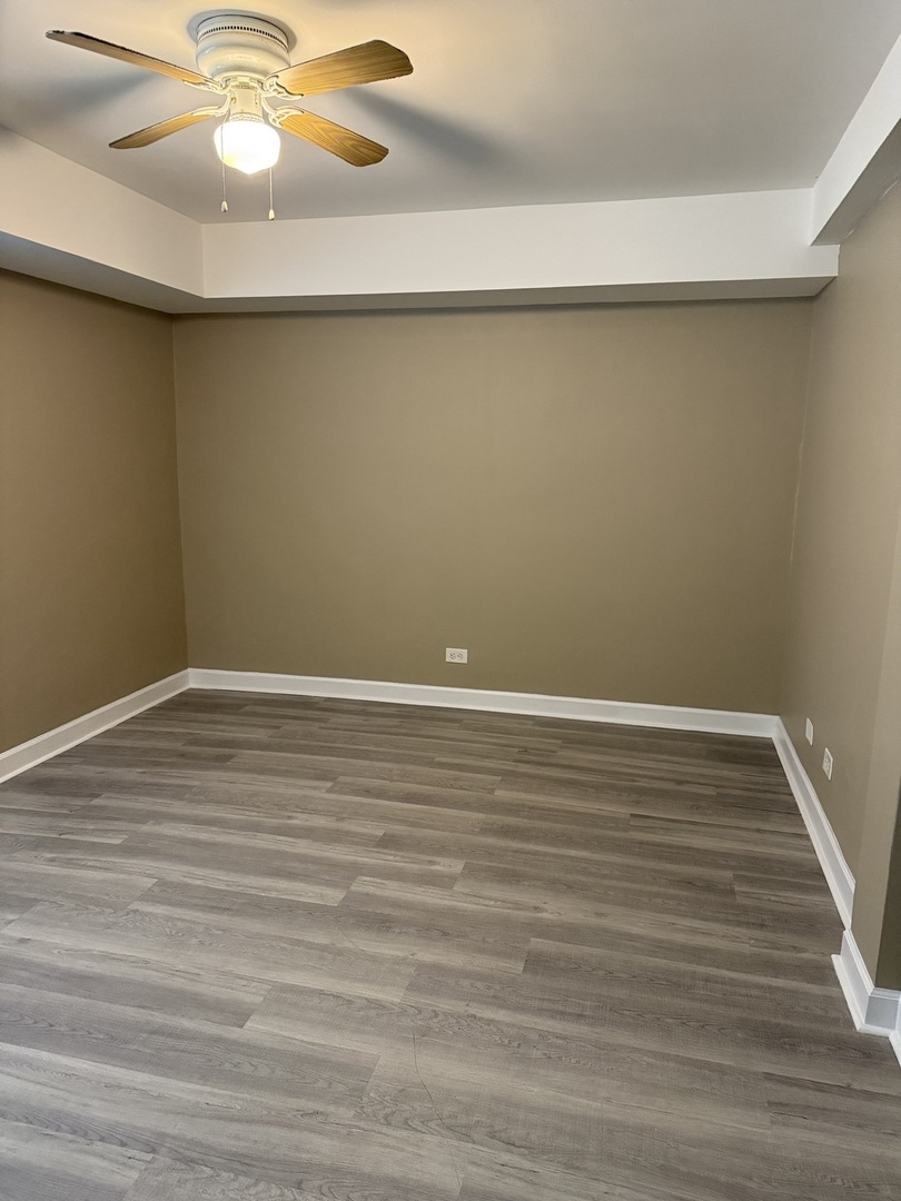 201 Custer Avenue, Unit G Evanston, IL 60202 - Photo 5 of 9 a view of a room with wooden floor and fan