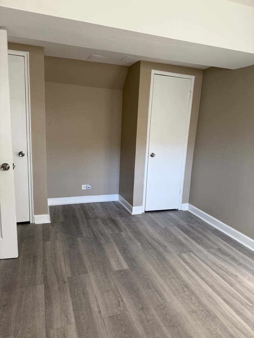 201 Custer Avenue, Unit G Evanston, IL 60202 - Photo 6 of 9 a view of an empty room with wooden floor and closet