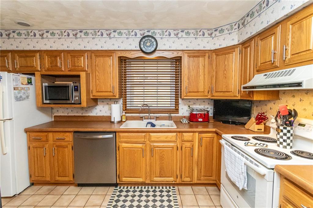 57 Russ Street Uniontown, PA 15401 - Photo 19 of 40 a kitchen with stainless steel appliances a stove a sink and a microwave
