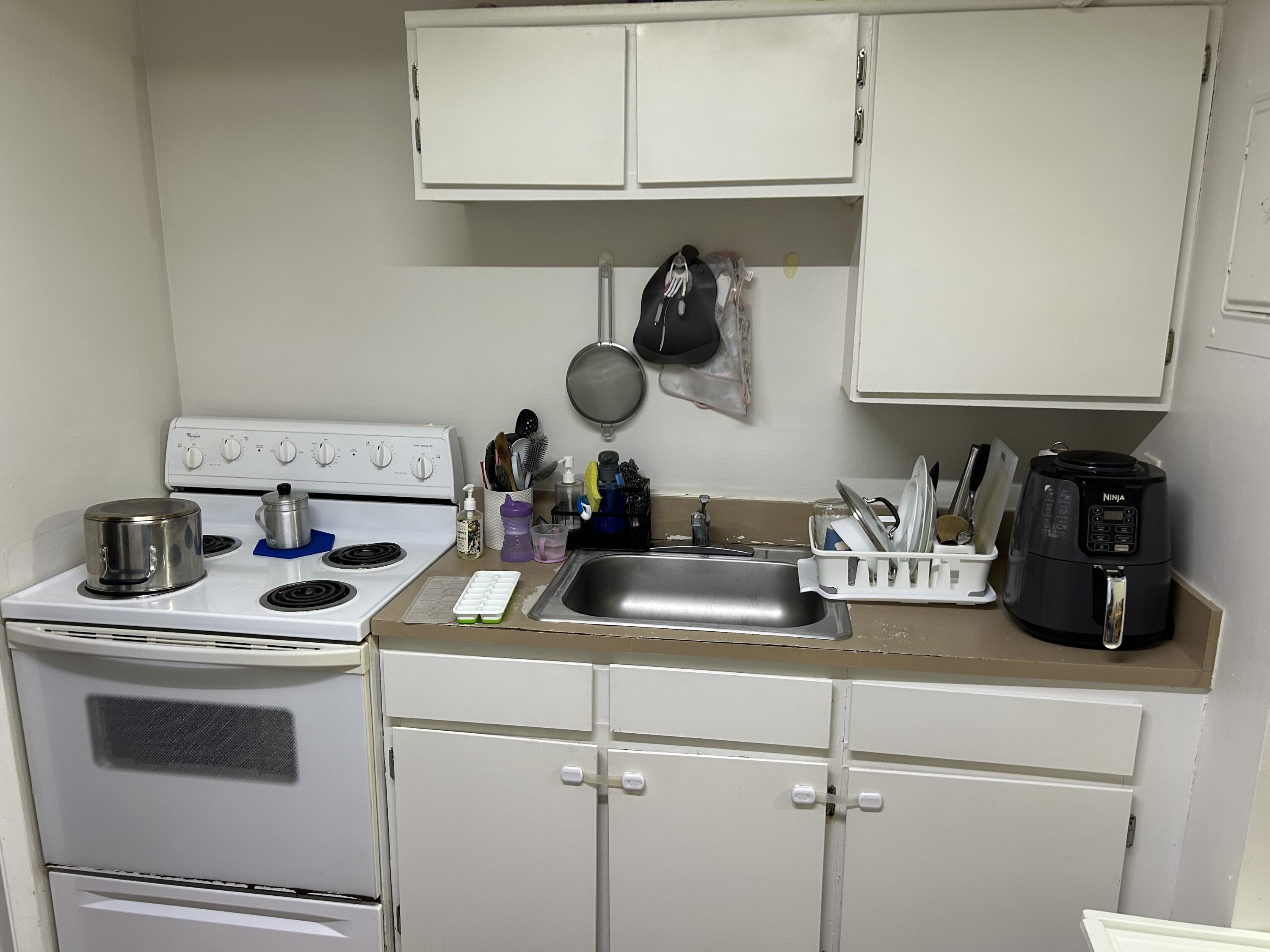333 Southeast Martin Avenue, Unit 47 Stuart, FL 34996 - Photo 3 of 11 a kitchen with a microwave a stove and cabinets