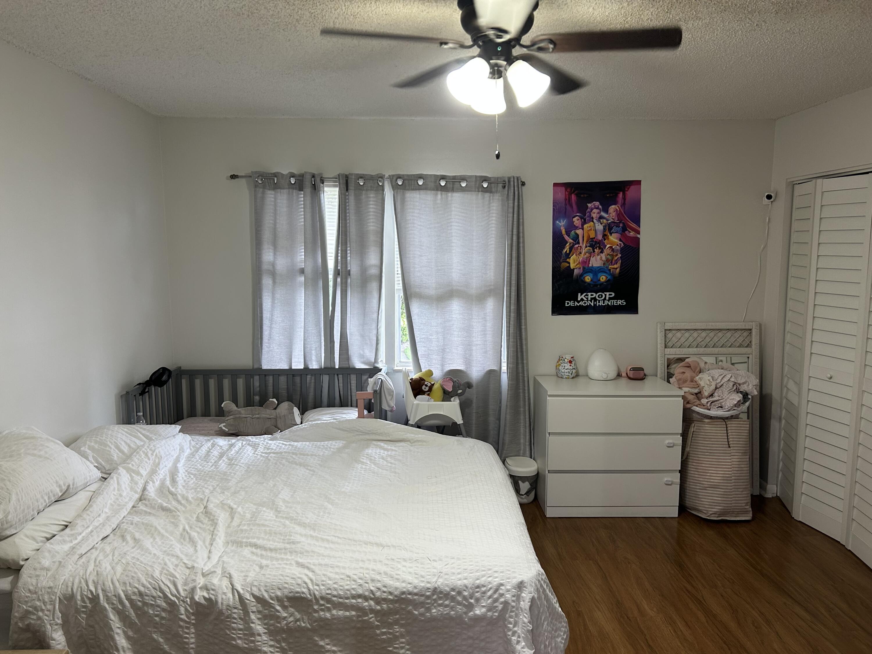 333 Southeast Martin Avenue, Unit 47 Stuart, FL 34996 - Photo 5 of 11 a bedroom with a bed and a chandelier