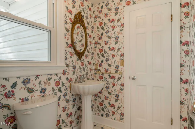 a bathroom with a sink and mirror with toilet