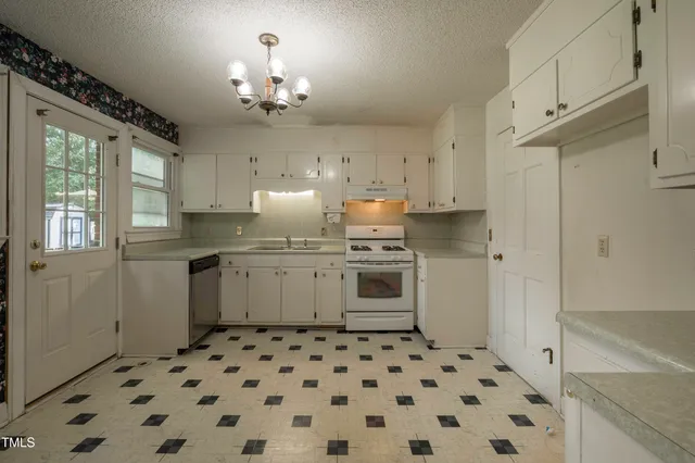 a kitchen with a sink a stove cabinets and refrigerator