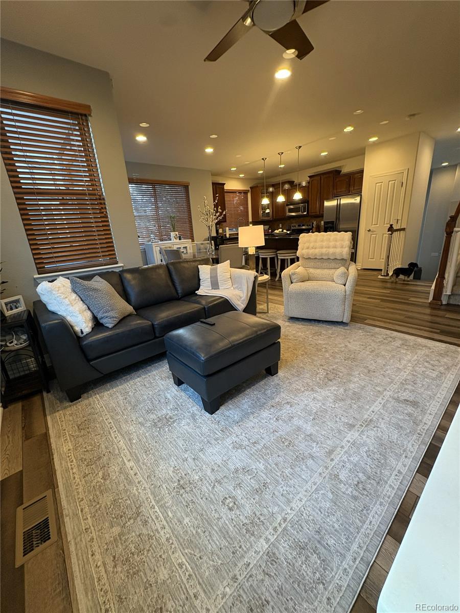 10158 RidgeGate Circle Lone Tree, CO 80124 - Photo 5 of 15 a living room with couches and kitchen view with wooden floor
