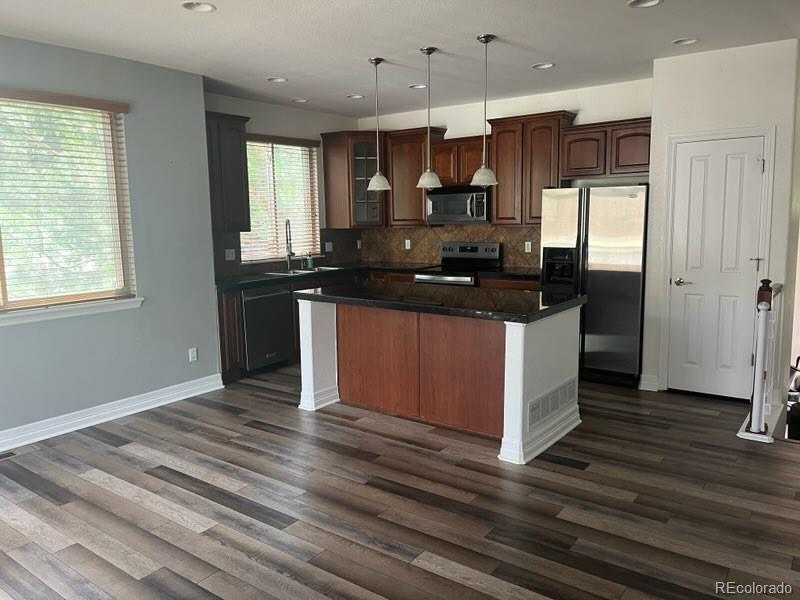10158 RidgeGate Circle Lone Tree, CO 80124 - Photo 7 of 15 a kitchen with stainless steel appliances granite countertop a stove and a refrigerator